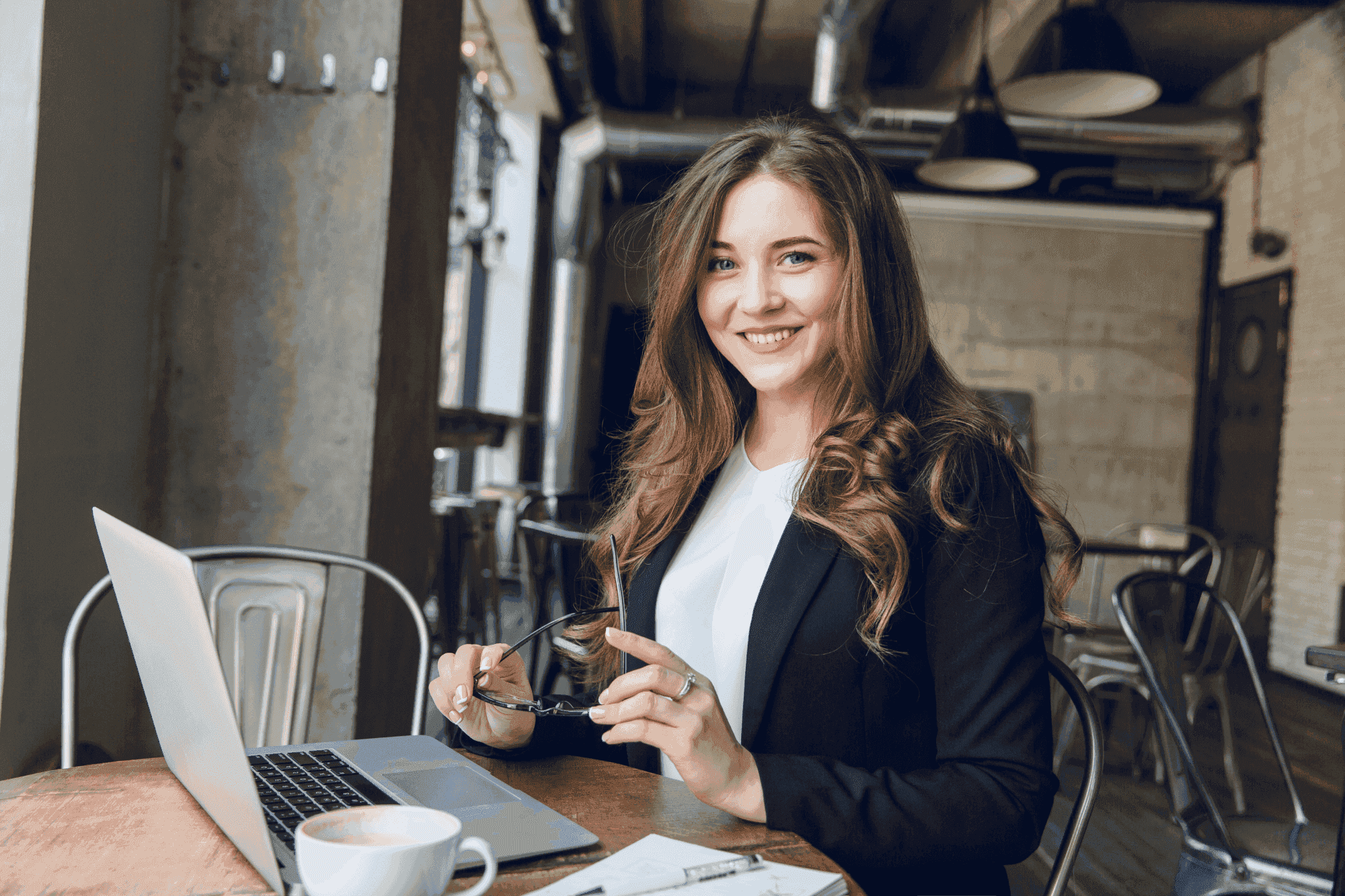 widely-smiling-businesswoman-working-laptop-sitting-cafe
