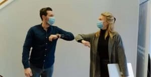Two Colleagues greeting each other with elbow touch